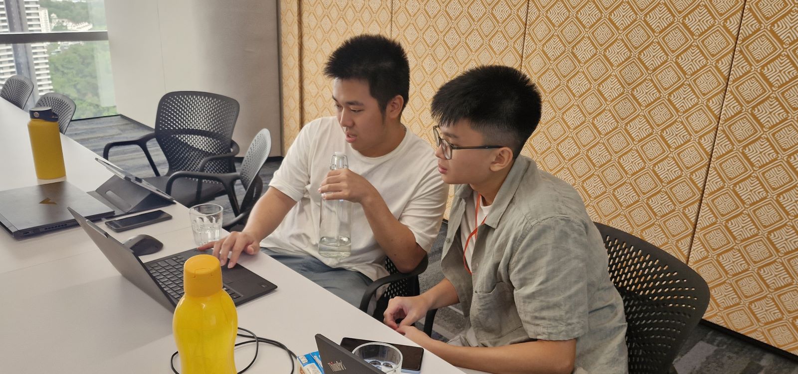 Two boys looking at a laptop, deep in thought