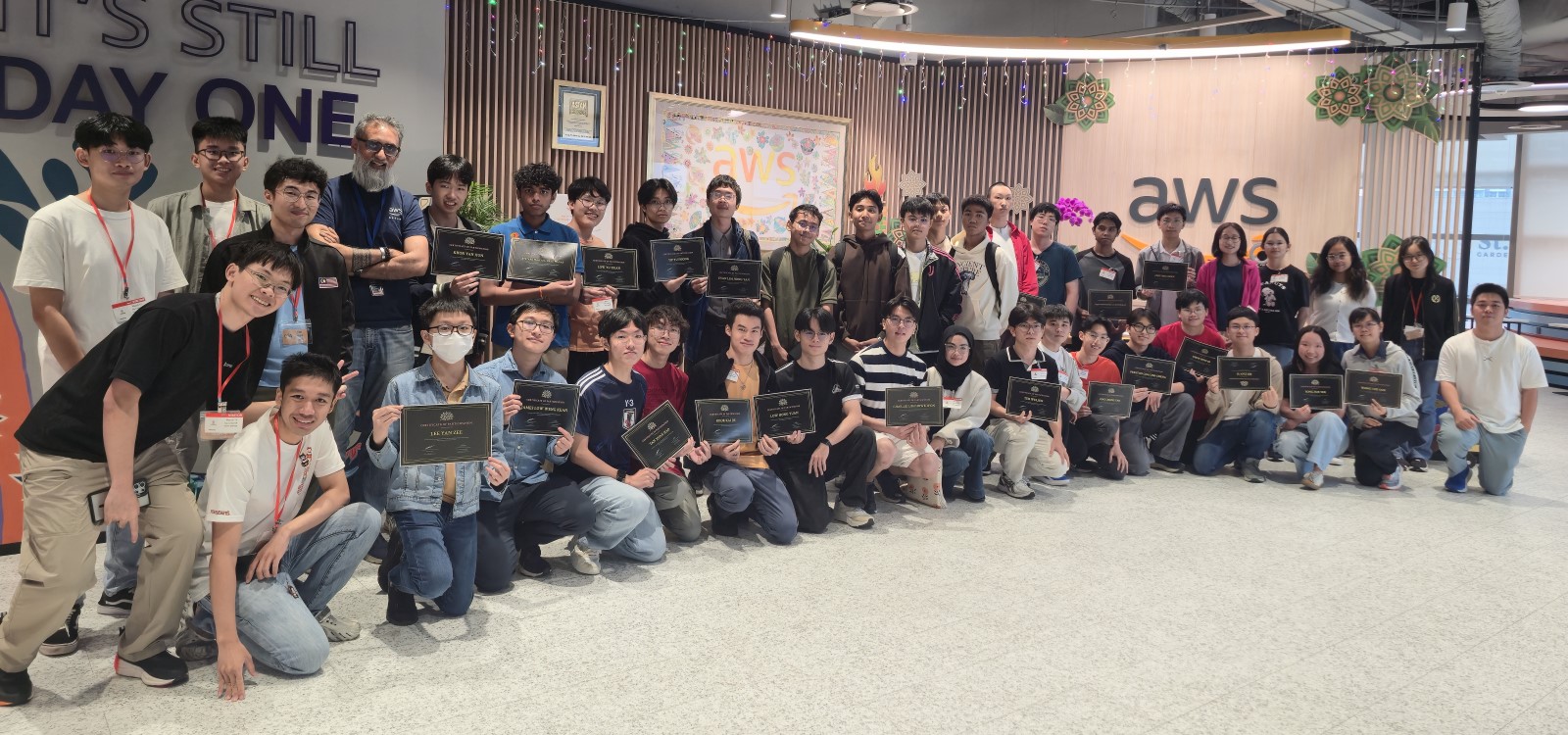 MAIO 2026 participants group photo at AWS KL office entrance