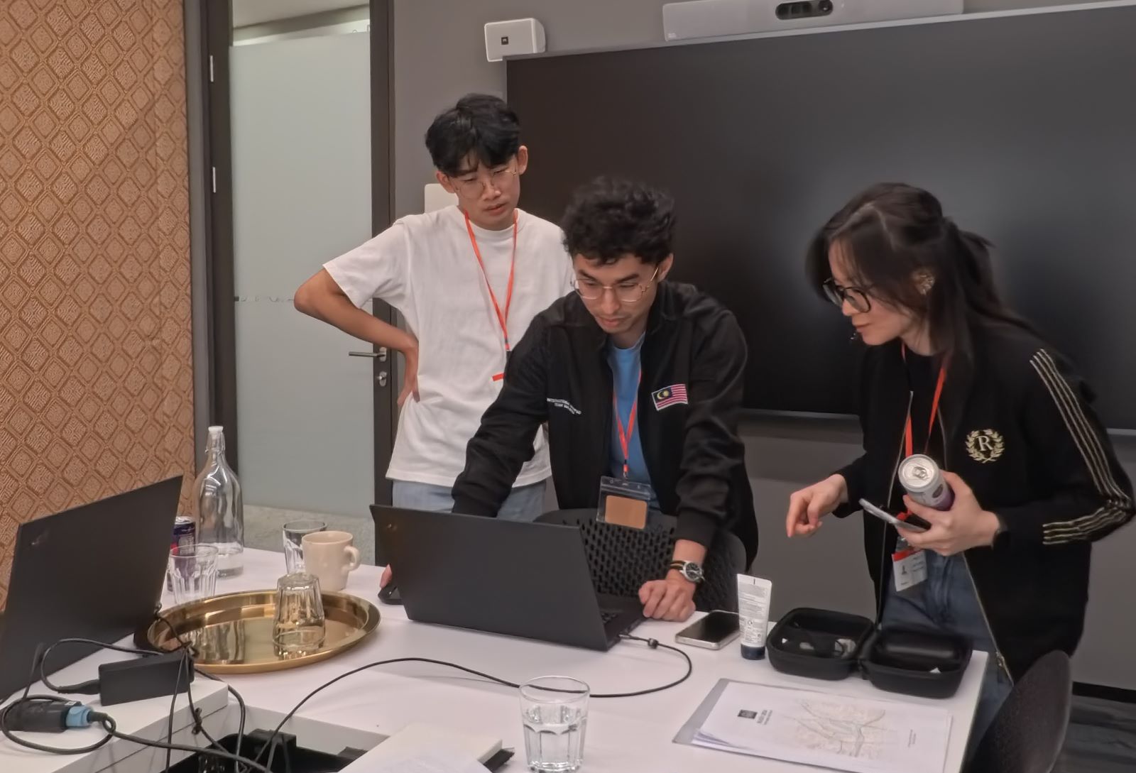 Three people looking at a laptop, deep in thought