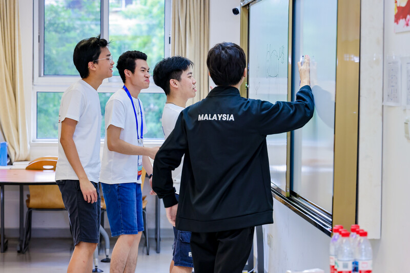 Students discussing problem at whiteboard